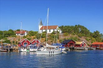 Boats and boathouses by the church in Hamburgersund on the Swedish west coast on a sunny summer