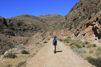 Woman walking along coast path in Cabo de Gata national park, near San José, Almeria, Spain, Europe