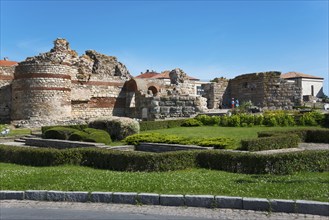 Ancient ruins under a clear blue sky with visitors exploring the historic site, Western Fortress