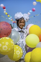 Happy schoolgirl with colourful balloons on the first day of school, Issyk-Kul region, Kyrgyzstan,