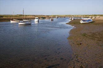 Boats in a tidal creek at Burnham Overy Staithe, north Norfolk coast, England, United Kingdom,