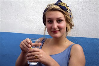 Model released portrait of teenage girl sitting holding a drink, UK