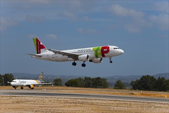 Two aeroplanes, Portugal on approach, Condor on the runway, sunny day with slightly cloudy sky,