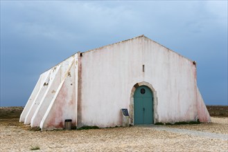 A solitary, weather-beaten building with a white façade under a cloudy sky, Historic Assembly and