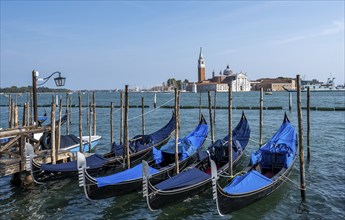 Venetian gondolas, boat mooring at St Mark's Square, church of San Giorgio Maggiore in the