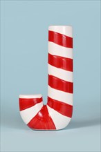 Red and white striped Christmas candy cane on blue background