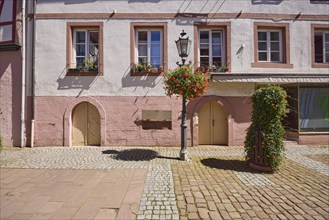 Facade of a house with cellar hatches and lantern on the alleyway Große Gasse in Michelstadt,