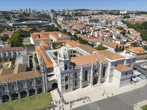 Aerial view of a cathedral with dome and towers, in the middle of a city with orange-coloured roofs