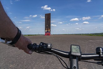 Cycling in the Ruhr area, on the Schurenbach slag heap, Bramme landmark for the Ruhr area by artist