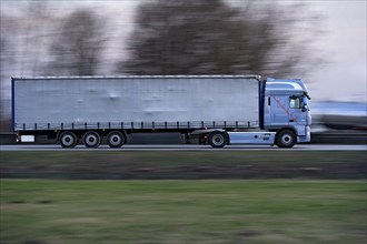 Truck, lorry, articulated lorry driving fast on the A92 motorway, motion blur, wiping effect,