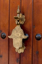 Traditional door knocker in hand shape, door fitting, door, brass, hand, entrance, knocking,