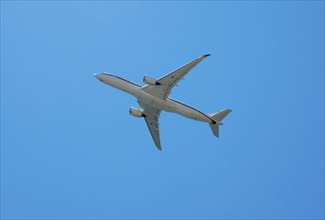 A large aircraft flies through a clear blue sky, Airbus A350 with the registration number 10 plus