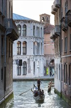 Gondola with tourists in the side canal of the old town, old building, city trip, holiday, travel,