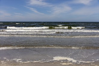 Foamy waves crash onto the coast in sunny weather and blue skies, Rügen, Hiddensee