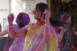 Women covered in colourful dye celebrating the Holi festival, Festival of Colours in Mathura, Uttar