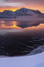 Mountains reflected in lake, dawn, fog, winter, snow, icy, Lake Kochel, Alpine foothills, Bavaria,