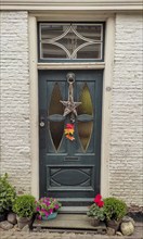 Old front door with decoration and flower arrangements, Skoten, province of Friesland, Netherlands