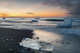 Small icebergs on the beach during sunset, long exposure, Diamond Beach, glacier lagoon Jökulsárlón