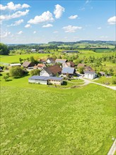 Aerial view of an extensive meadow landscape with a village and farmhouses, glass fibre