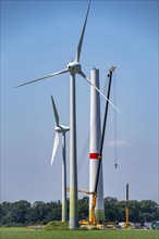 Erection of the tower of a wind power plant in a wind farm near Issum, 9 older wind turbines from