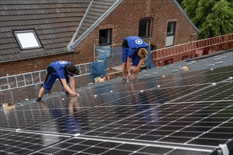 Installation of solar modules on the roof of a barn on a farm, over 240 photovoltaic modules are