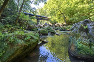 The Irrel Waterfalls, rapids in the lower reaches of the Prüm, covered wooden bridge for hikers,