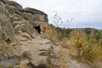 Klusfelsen with colourful autumn leaves, prehistoric cult site in the Harz Mountains, cave served