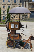 Old camera on wheels with umbrella on a cobblestone square, camera, Santiago de Compostela,