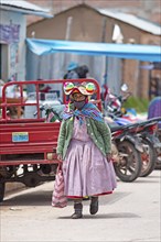 Peruvian woman in traditional dress at the market in Cocotos on Lake Titicaca, Puno province, Peru,