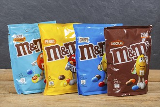 Various types of M&M's chocolate lentils from Mars Inc. on a wooden board