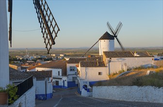 Village with white houses and a windmill at sunset, windmills and village, Campo de Criptana,