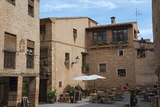 A cosy pavement café among historic buildings in a small, sunny town centre, Rafael Ayerbe Square,