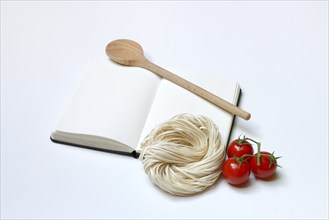 Notebook for recipes, cooking spoons, pasta and tomatoes