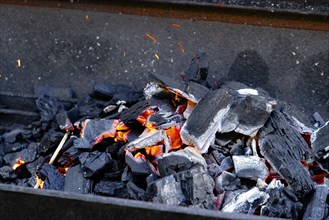 Hot glowing charcoal with sparks and flames, ready for grilling