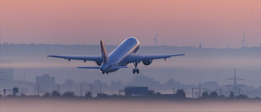 Passenger aircraft after take-off, in front of sunrise, fog, Baden-Württemberg, Germany, Europe