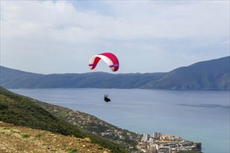 Paraglider taking off from mountainside above the Adriatic Sea at Vlore, Albania, Europe