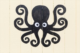 Octopus picture painted on side of wooden seaside beach hut, Felixstowe, Suffolk, England, UK