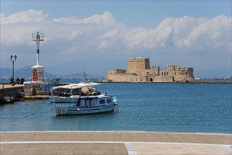 Small fishing boat in front of a historic fortress under blue sky with clouds, Fortress, Bourtz