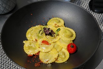 Ravioli, Italian dumplings, filled, pasta served on a plate, primo piatto, 1st main course, cherry