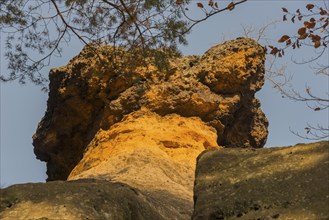 Close-up of a bright orange rock formation with trees and blue sky, Kokorinske poklicky rock