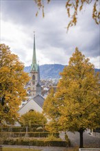 Autumnal city view with church tower and colourful trees, Zurich, Switzerland, Europe