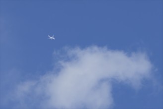 Boeing 787-8 Dreamliner jet aircraft of Qatar airlines flying in a blue sky with a white cloud,