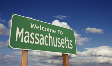 Welcome to massachusetts green road sign over blue sky with some clouds