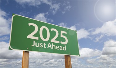 2025 just ahead green road sign over clouds and blue sky