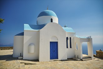 White and blue church with striking blue entrance and sea view in the background, Church of