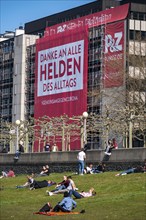 A construction company has hung a large poster on a building facade on the Rhine promenade,