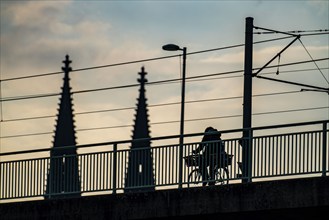 Cycling in the city, cyclist on the Deutzer Bridge in Cologne, Cologne Cathedral, cycle path, North