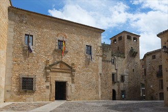 A square with old stone buildings and Spanish flags, palace, Palacio de los Golfinos de Abajo,