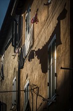 House facade with washing line in the afternoon sun, old town, atmospheric, backlight, sun, evening