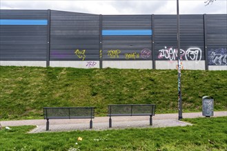 Green space, in Duisburg-Beck, park bench with view of the noise barrier of the A42 motorway,